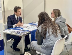 Hombre presentando a dos chicas de un colegio las oportunidades que tienen